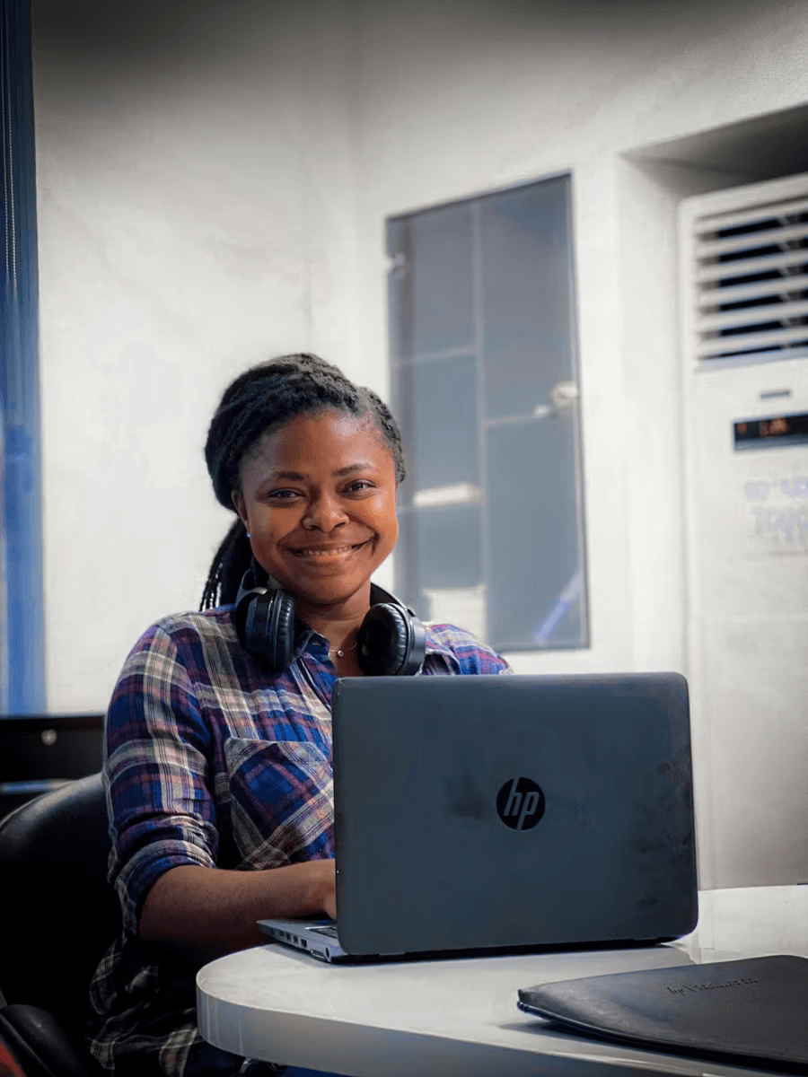 Tutor smiling while seated behind a laptop